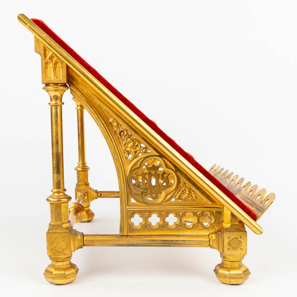 A stand for a Missale Romanum made of gilt bronze in neogothic style and finished with red fabric. (H:35cm)