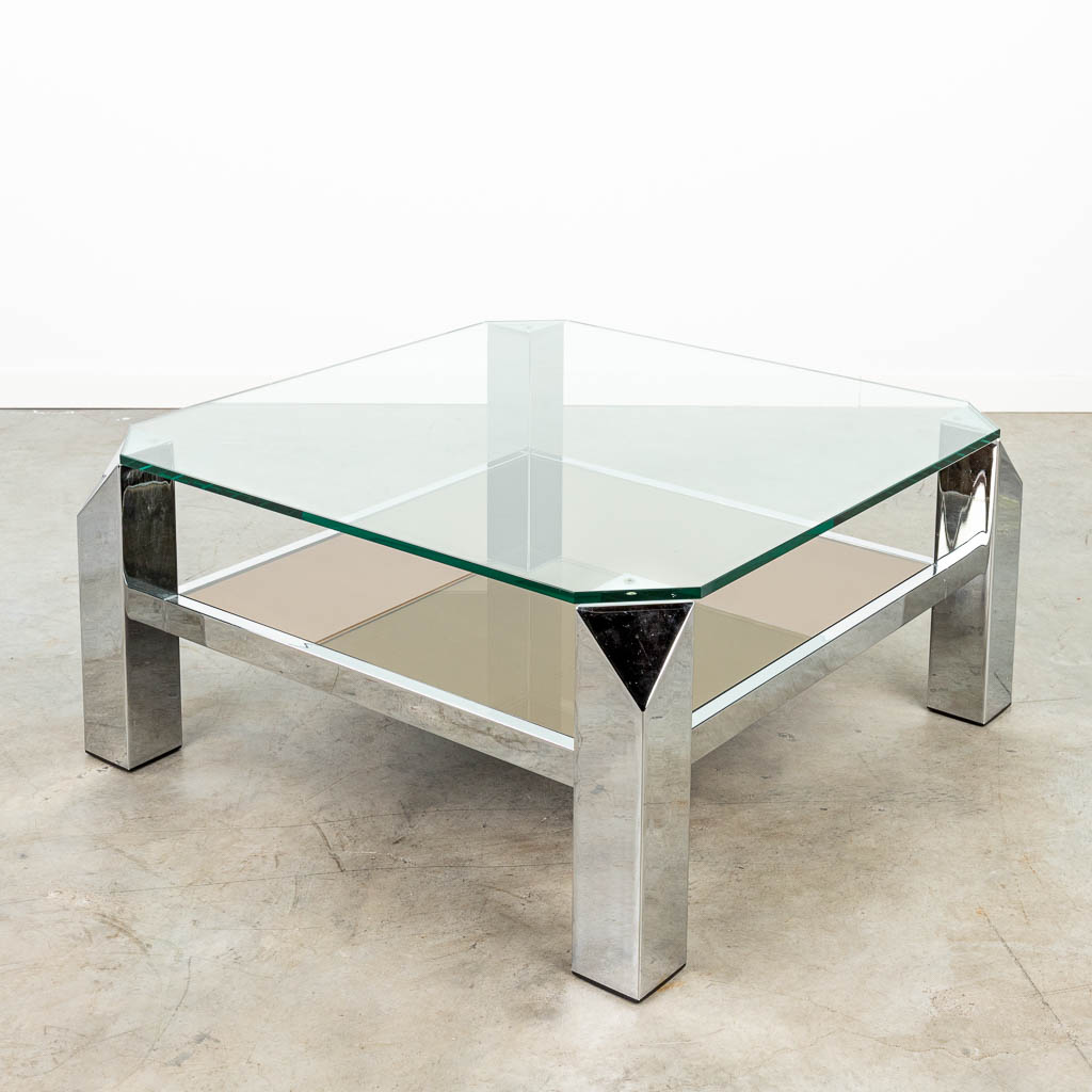 A coffee table made of chome-plated metal with fumé and clear glass.