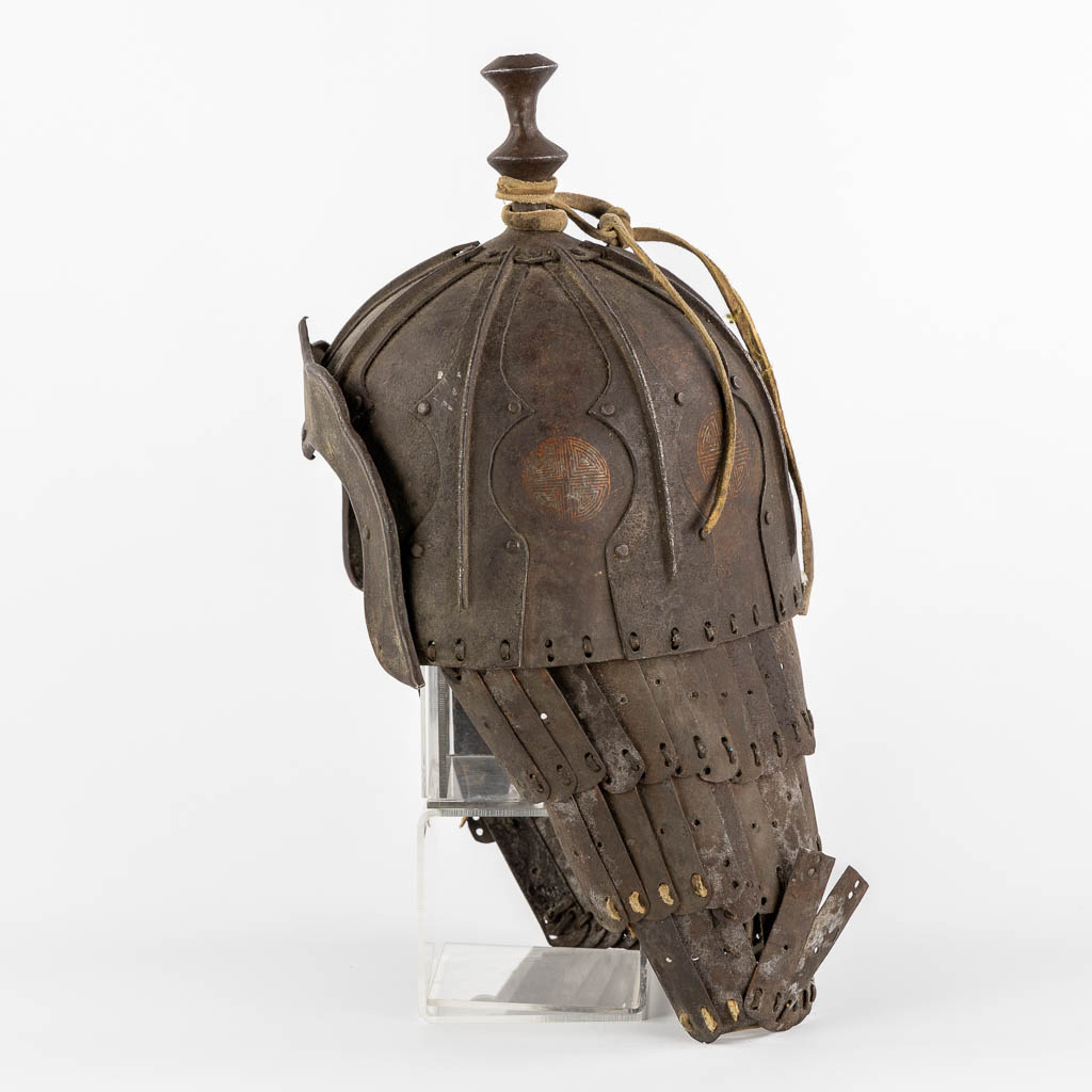 Een Tibetaanse militaire helm, metaal en leder. 18de/19de eeuw. (L:20 x W:24 x H:42 cm)