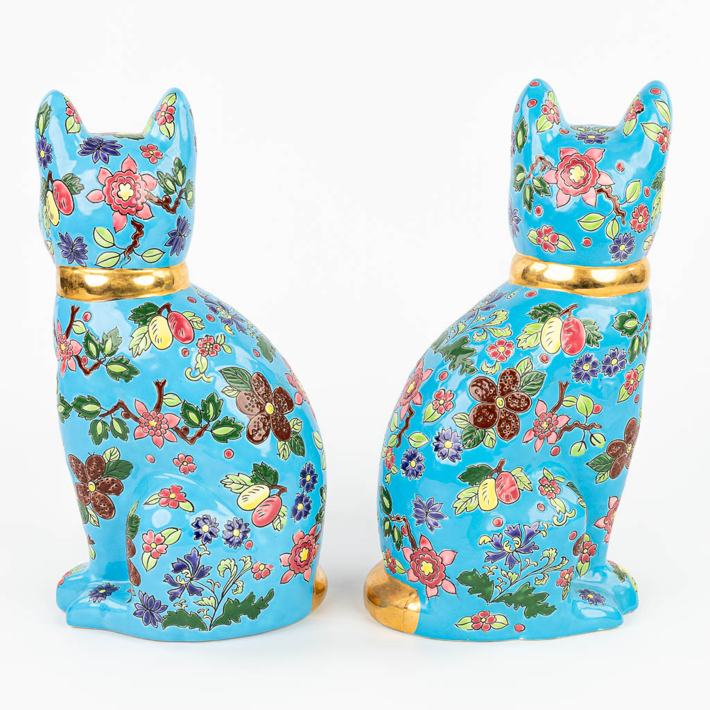 A pair of decorative cats made of glazed faience in the style of 