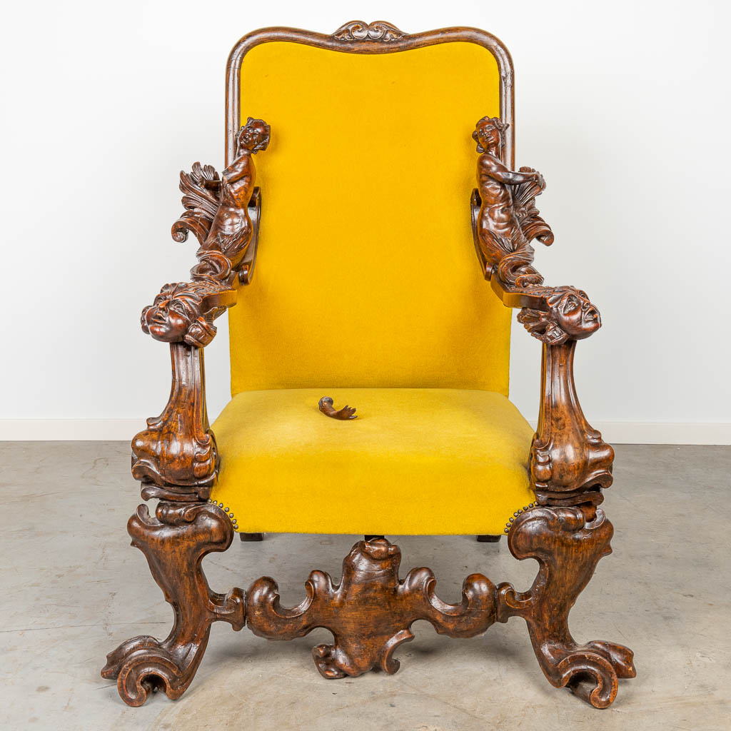 An armchair with richly decorated armrests in the style of Andrea Brustolon