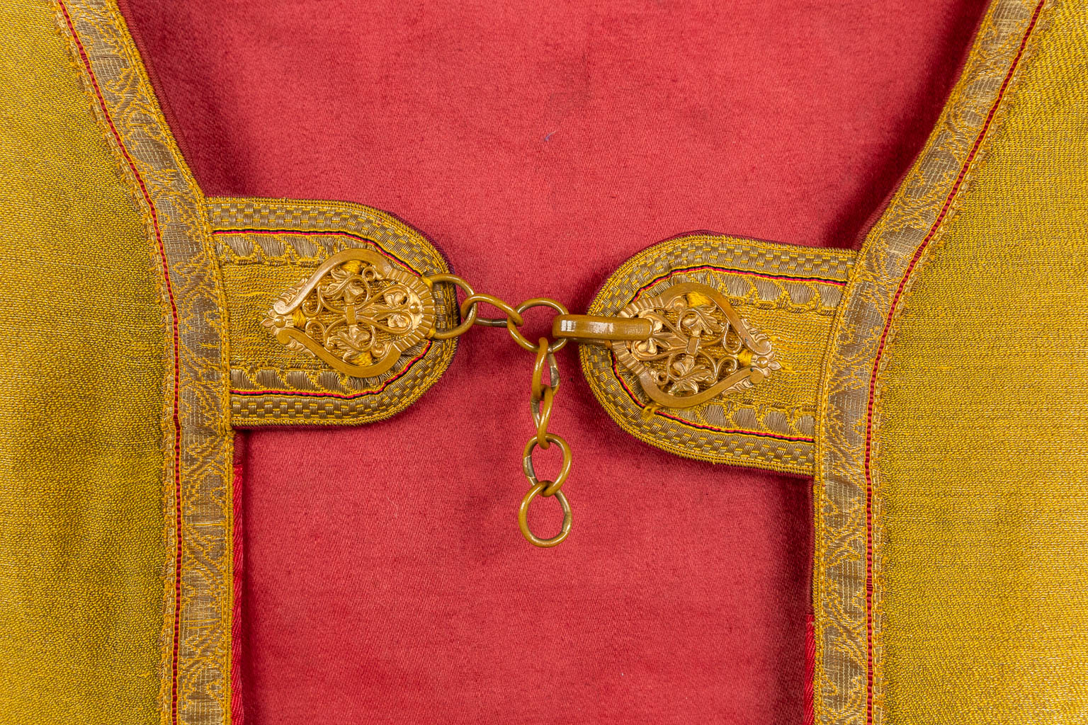 Een Koorkap, twee schoudervelums, een Romeinse kazuifel, afgewerkt met dik goudbrokaat borduurwerk.