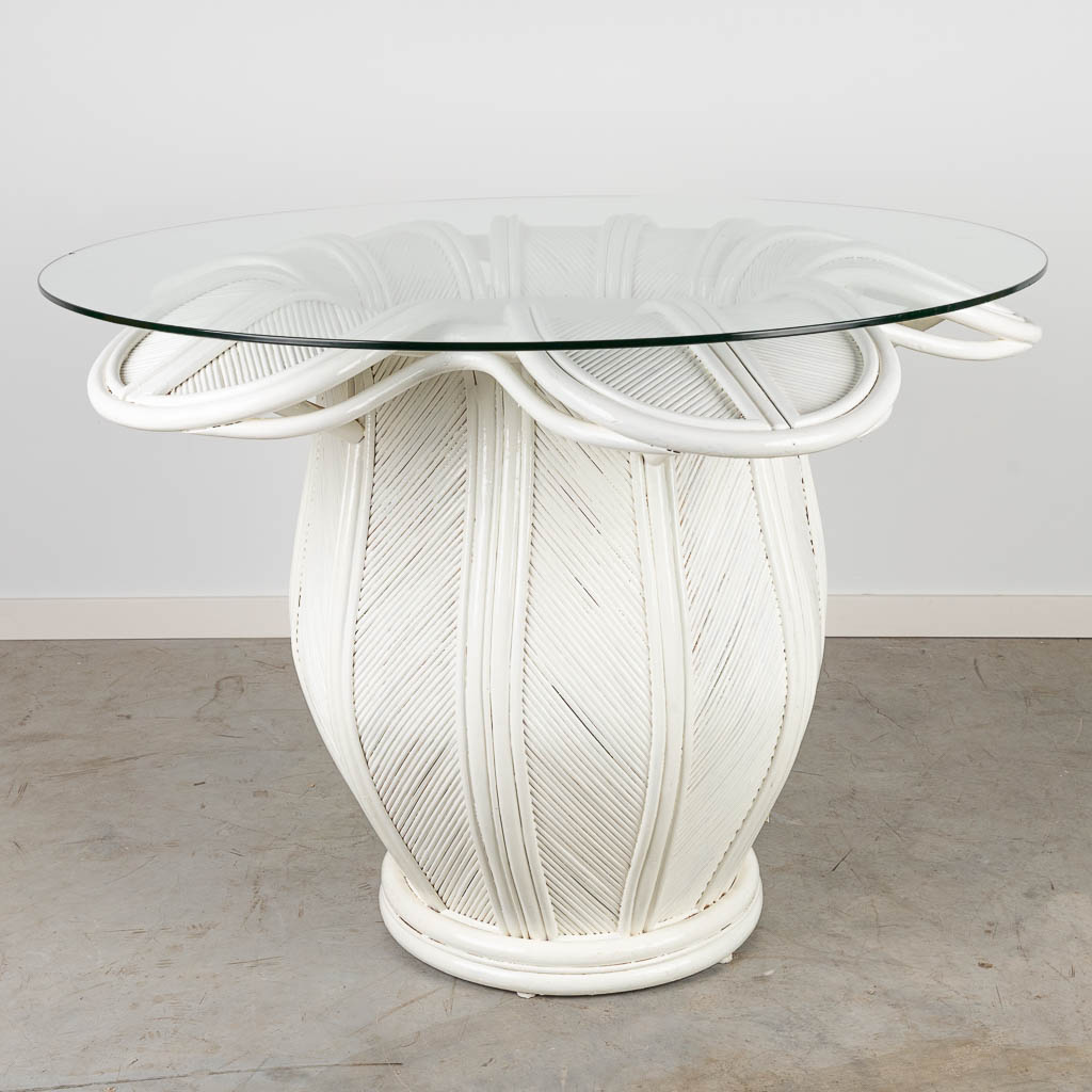 Een tafel gemaakt uit wit gepatineerde rotan in de vorm van een bloem