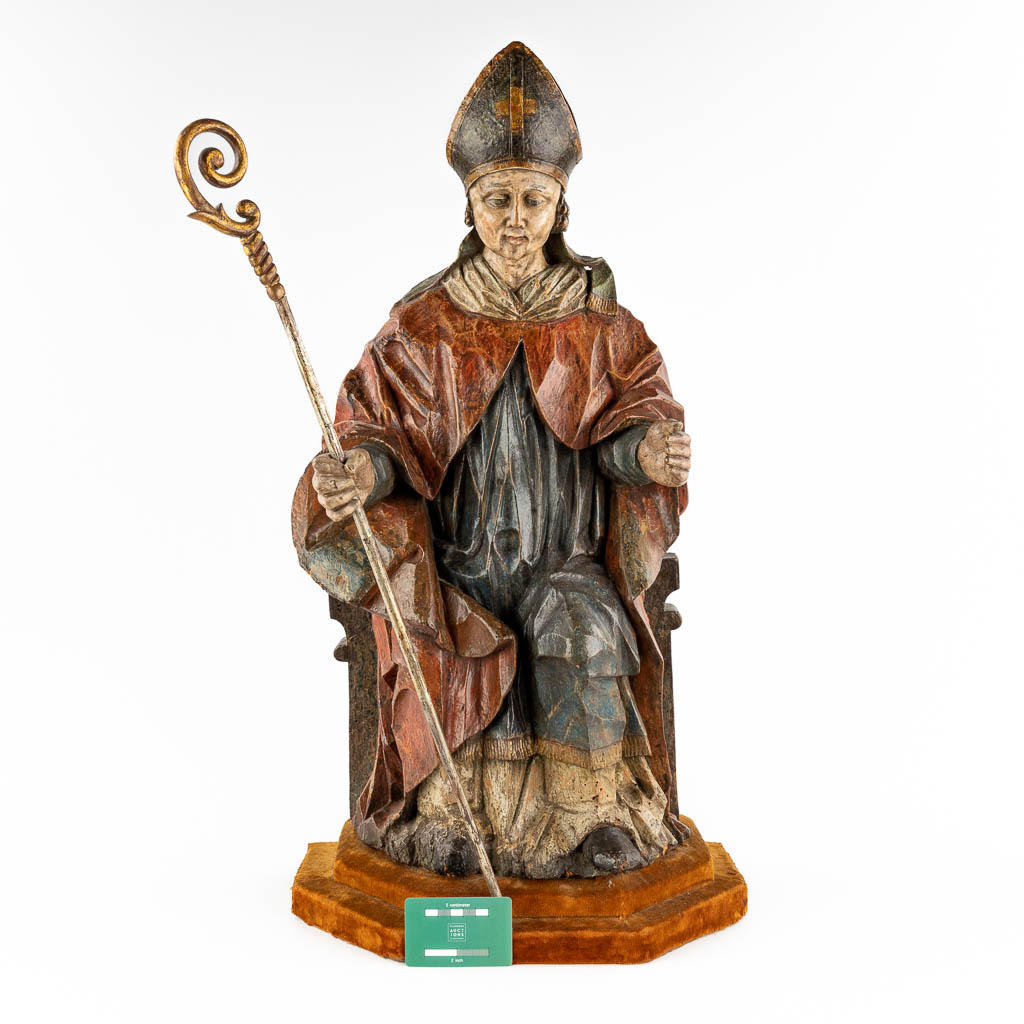 An antique wood sculpture of a Saint with his staff and mitre, polychromy. 18th C. (D:28 x W:38 x H:74 cm)