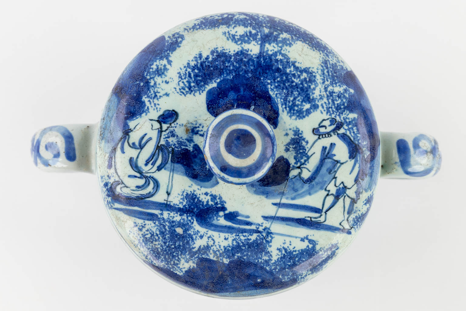 Delft Faience, a jar with two handles and a lid, decor of figurines in a landscape. 18th C. (D:12,5 x W:19 x H:11,5 cm)