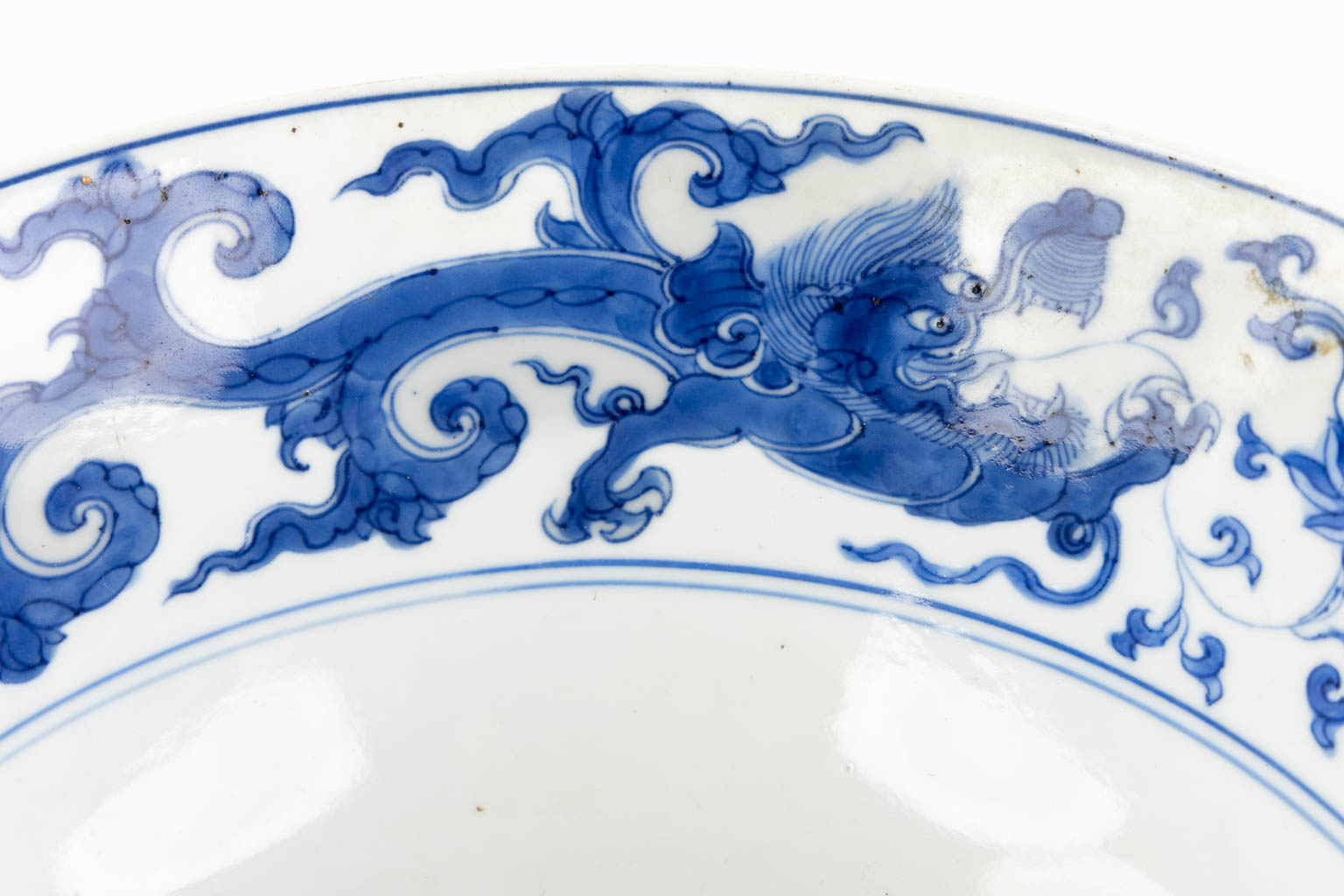 Een Chinese schaal met drakendecor, blauw-wit. Kangxi periode. (H:9,5 x D:21 cm)