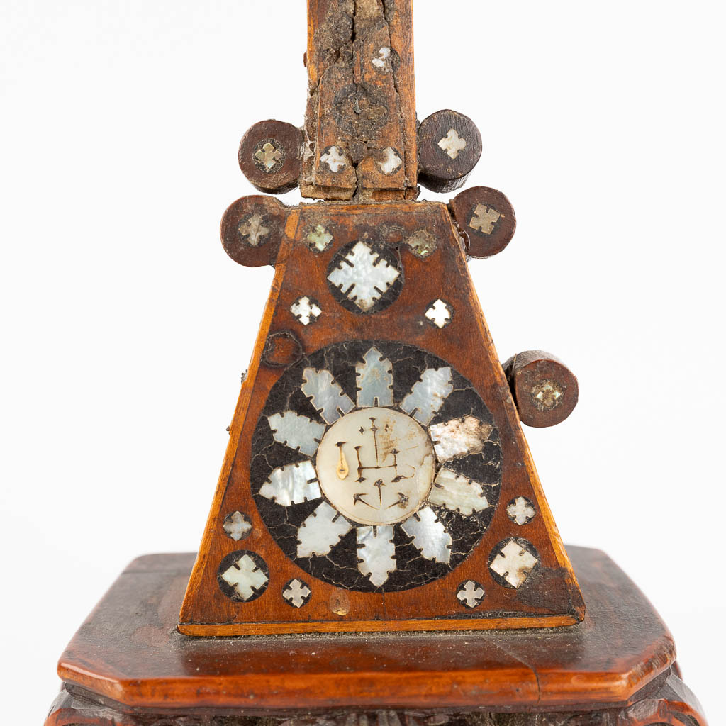 A crucifix made of sculptured palm wood, inlaid with mother of pearl. 19th C. (L: 6 x W: 13 x H: 25,5 cm)