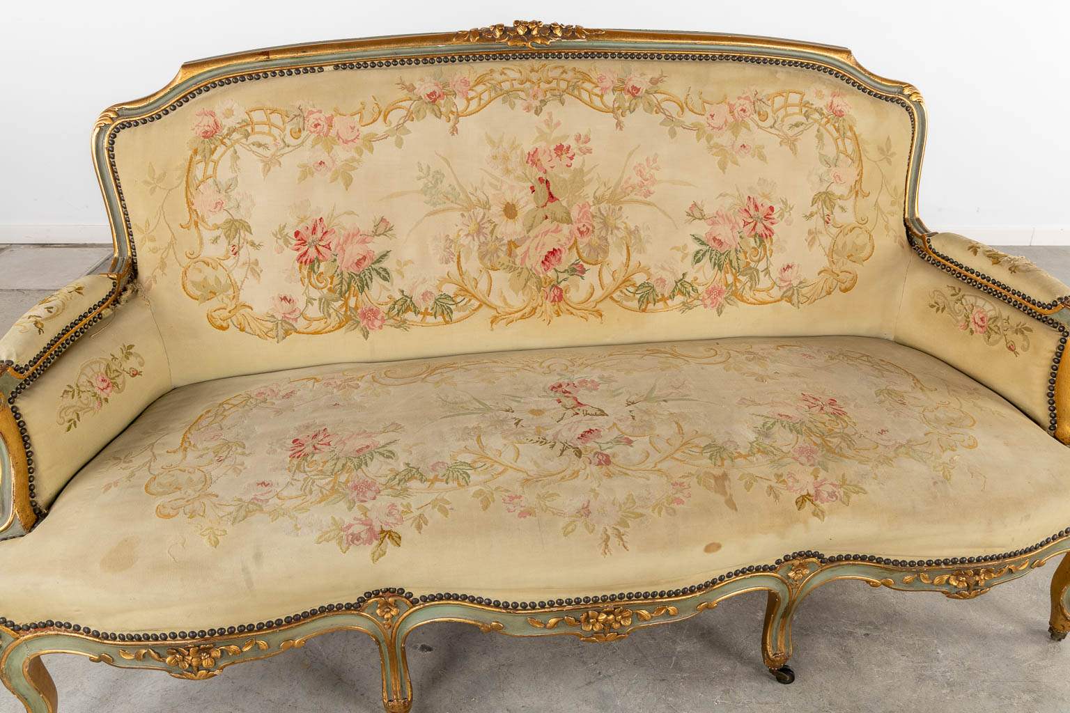 Een Lodewijk XV stijl zetel, overtrokken met bloemen borduurwerken. (L:80 x W:175 x H:96 cm)
