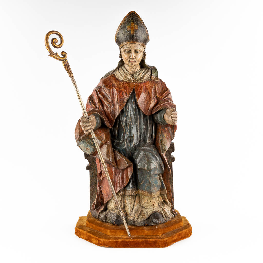 An antique wood sculpture of a Saint with his staff and mitre, polychromy. 18th C. (D:28 x W:38 x H:74 cm)