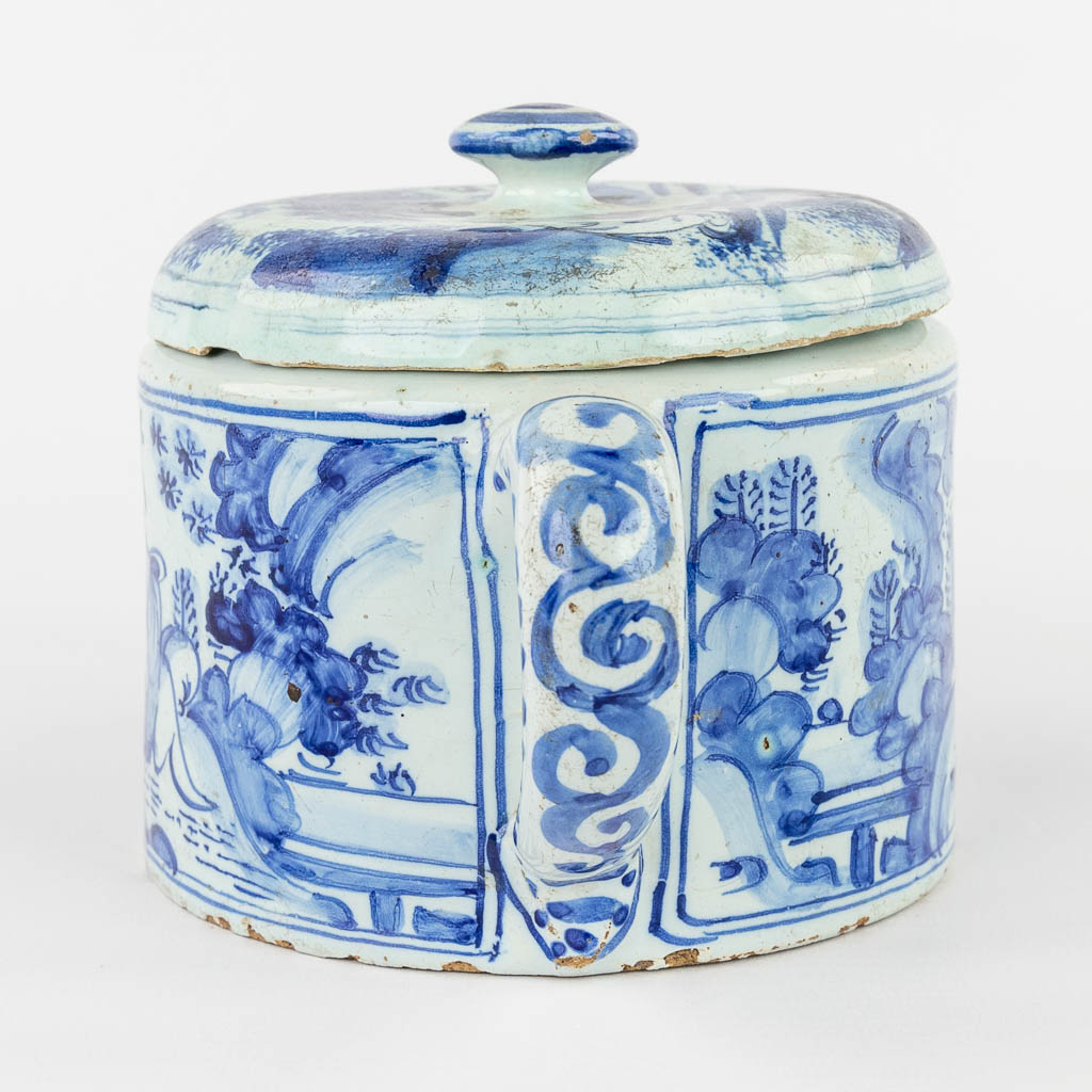 Delft Faience, a jar with two handles and a lid, decor of figurines in a landscape. 18th C. (D:12,5 x W:19 x H:11,5 cm)