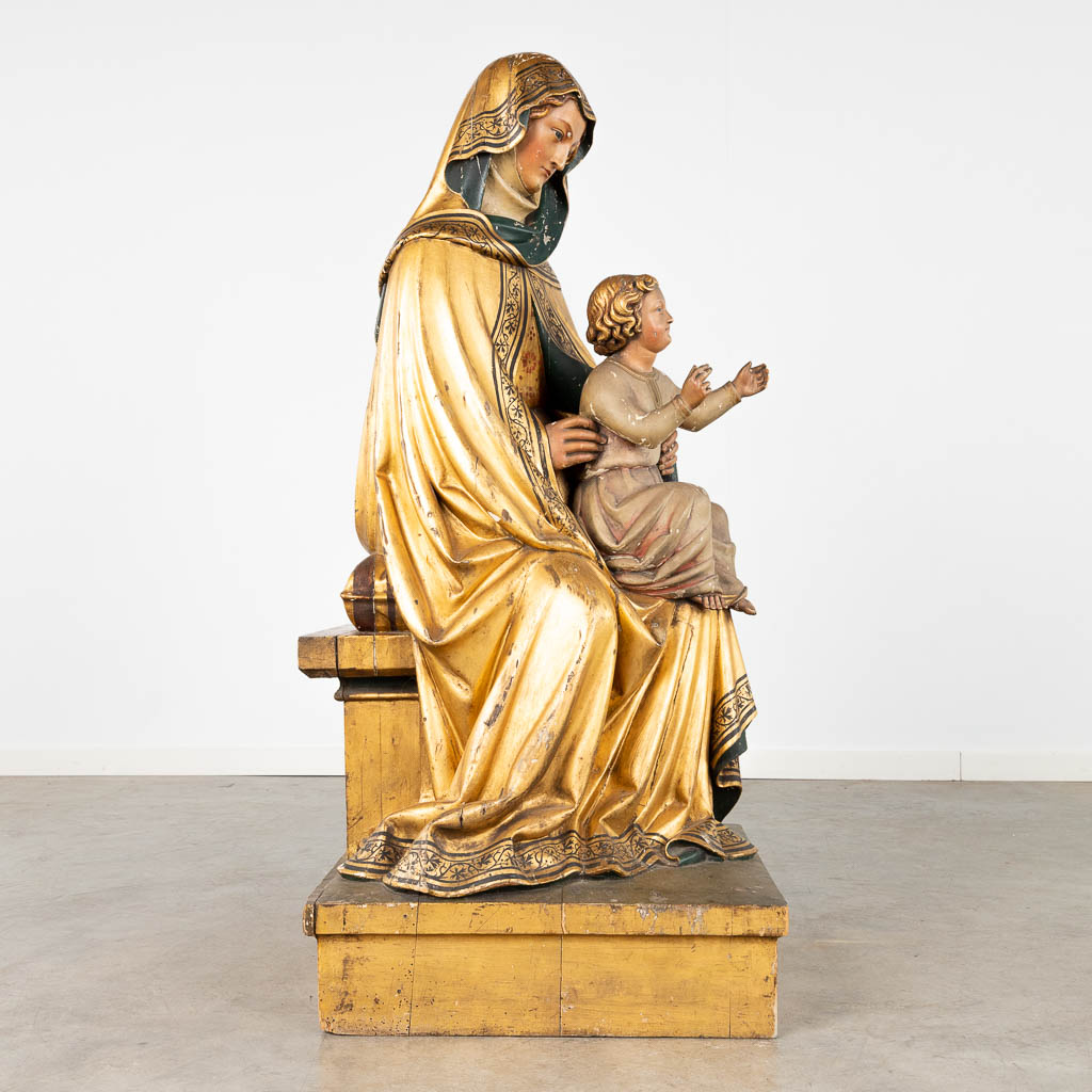 An antique wood-sculptured statue of Saint Anna with child, gilt and polychrome. 18th/19th C. (D:51 x W:58 x H:118 cm)