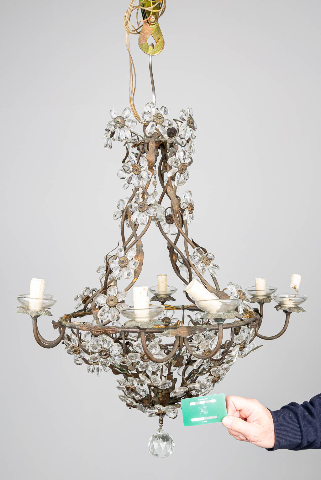 A large chandelier made of metal with glass flowers. 