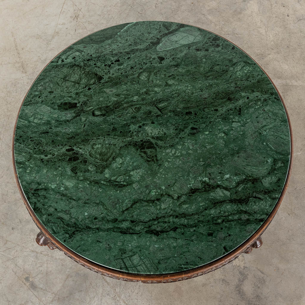 Een salontafel afgewerkt met mythologische figuren en een groen marmer blad. 20ste eeuw. (D:93 x W:93 x H:63 cm)
