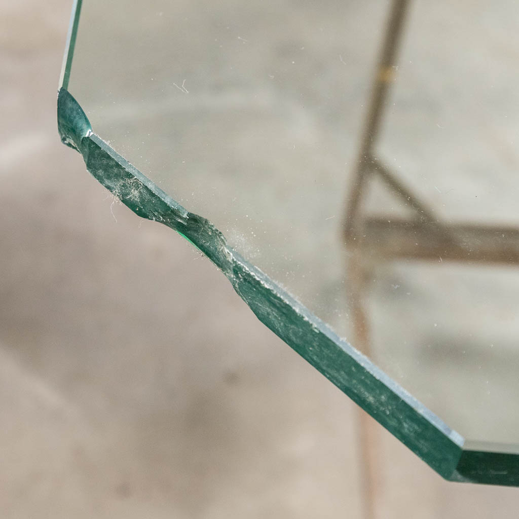 Een salontafel met travertin poten, glazen bovenblad. Circa 1980. (D:105 x W:105 x H:36 cm)