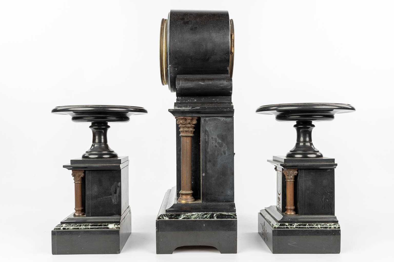 Een driedelige schouwgarnituur gemaakt uit zwarte marmer en gemonteerd met brons. (H:49cm)