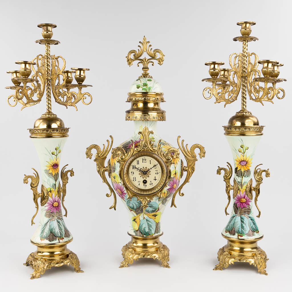 A three-piece mantle garniture clock and candelabra, circa 1900. (W: 34 x H: 63 cm)