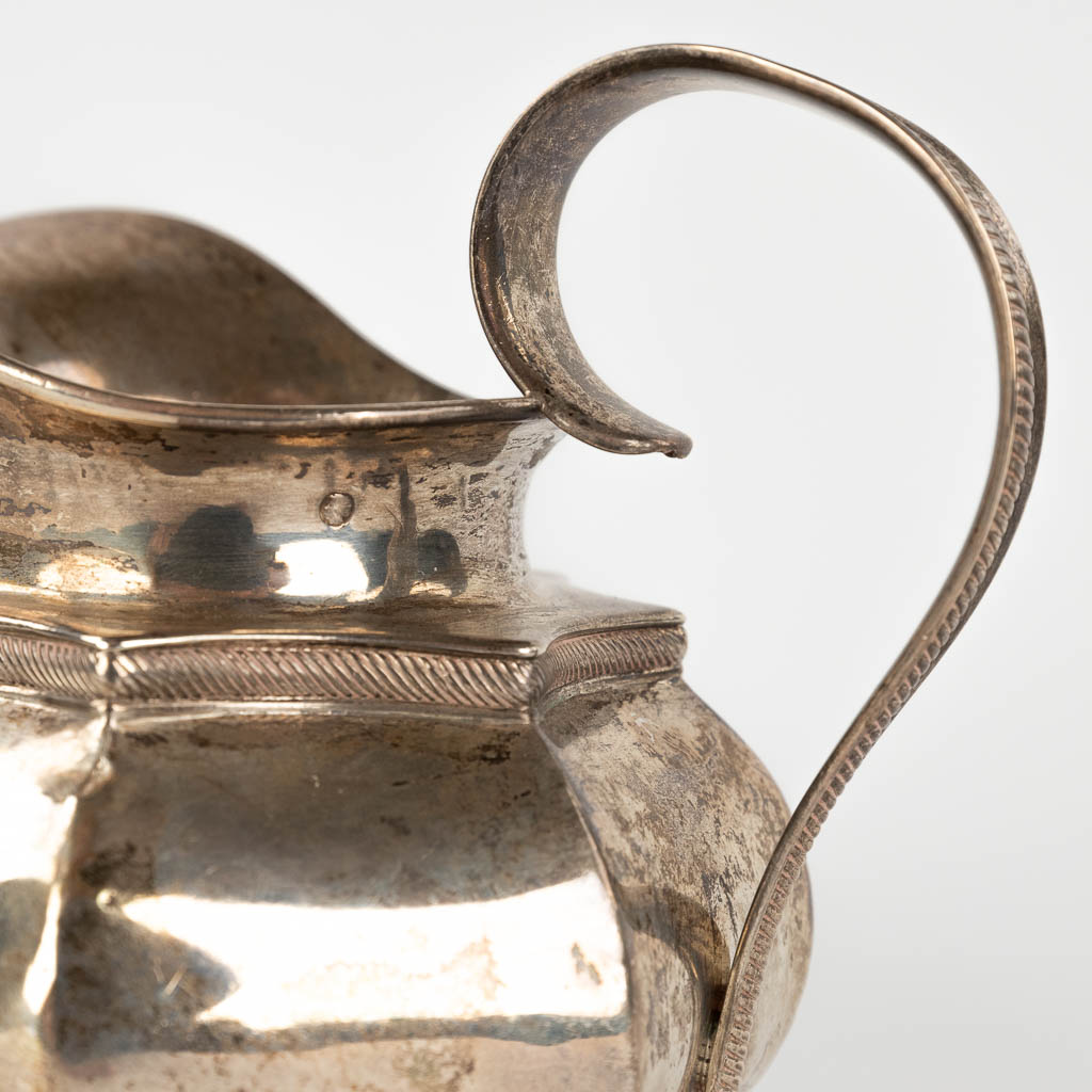 An antique milk jug, silver. The Netherlands, 19th C. 216g. (L: 10 x W: 12,5 x H: 12 cm)