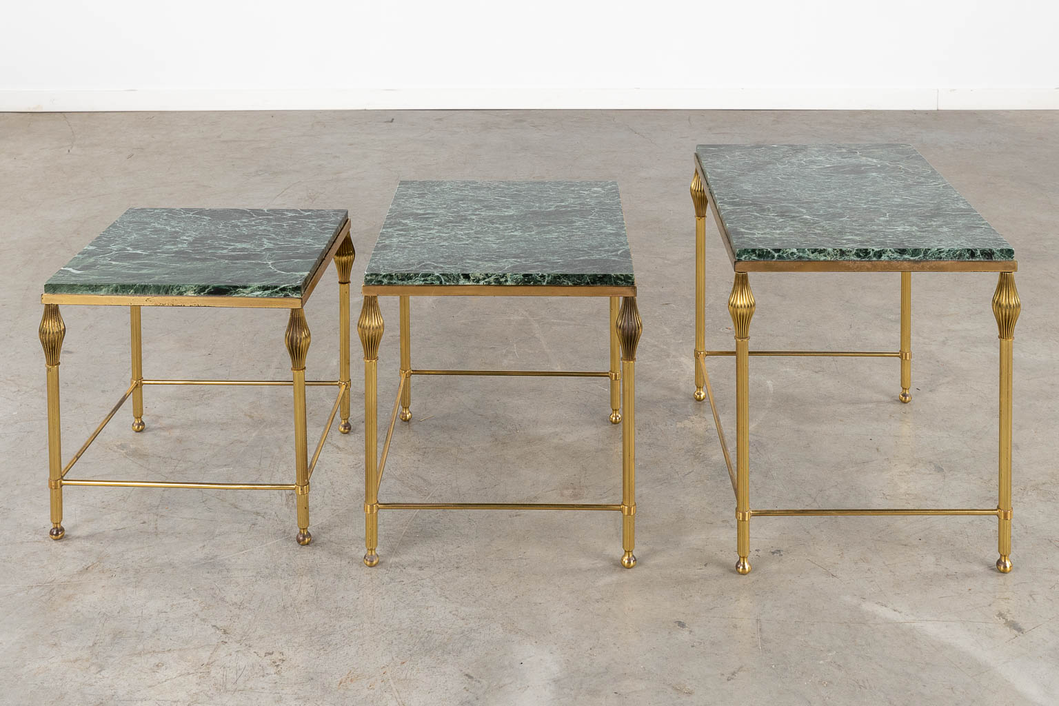 A three-piece set of nesting tables, gilt metal and a green marble. (D:37 x W:56 x H:45 cm)