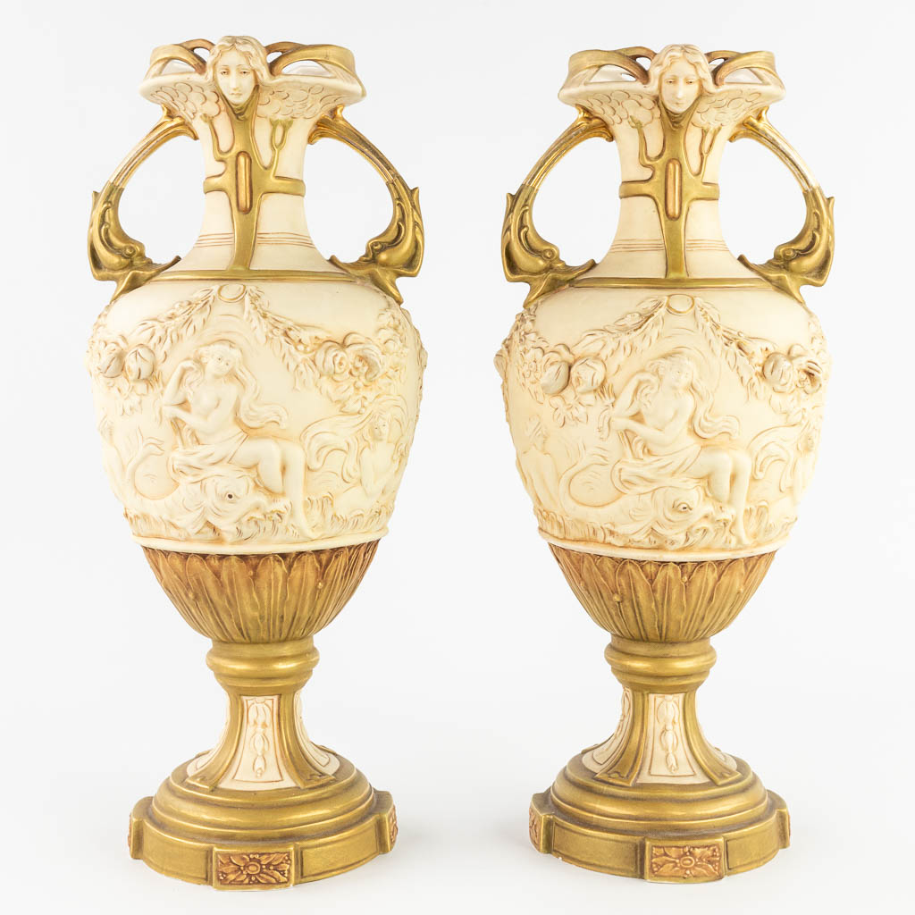 Royal Dux, een driedelige schouwgarnituur bestaande uit een romantische voorstelling en een paar vazen. (L:20 x W:28 x H:43 cm)