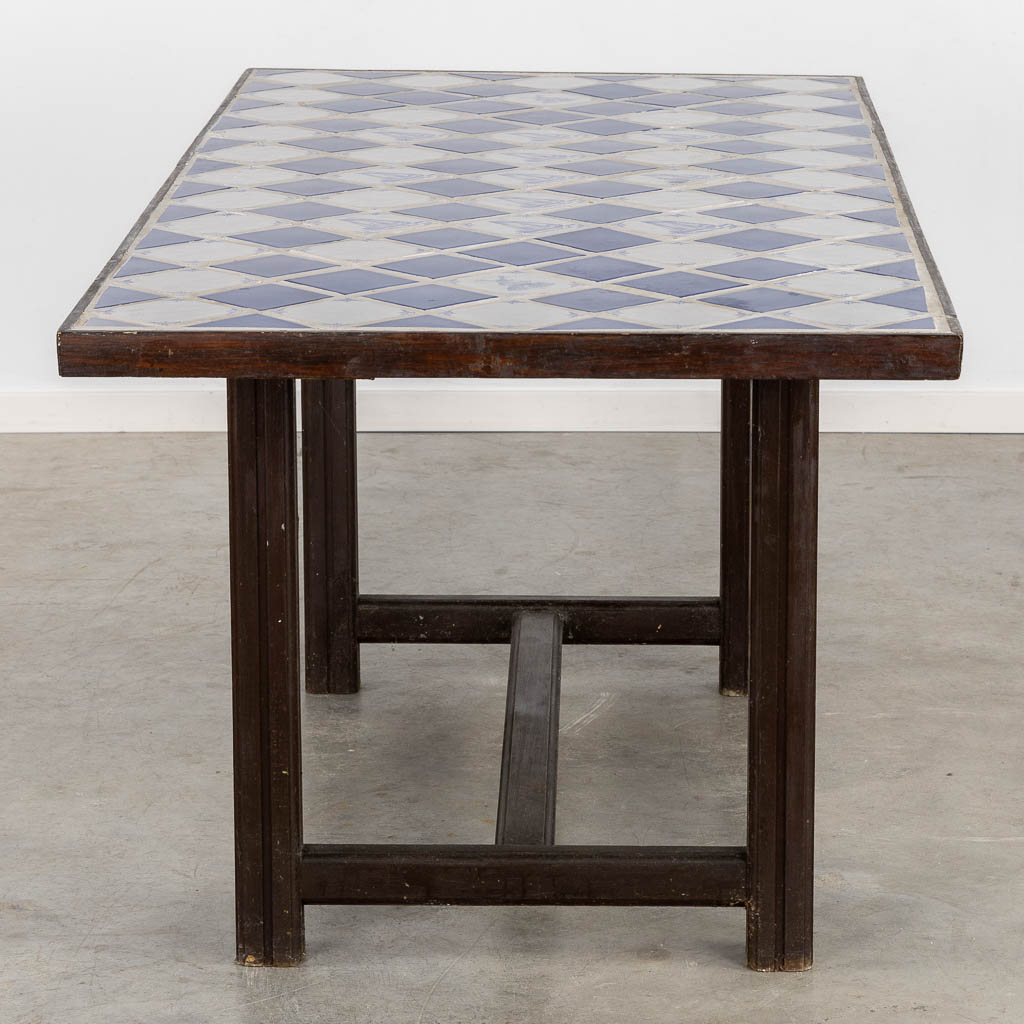 Een Spaanse tafel afgewerkt met blauwe en witte faience tegels. (L:85 x W:184 x H:76 cm)