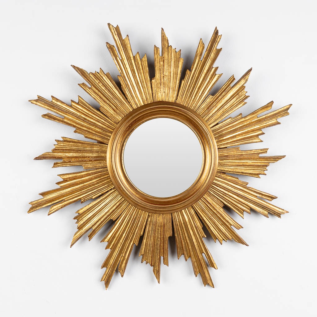 Deknudt, a gold plated sunburst mirror made of sculptured wood. (D:68 cm)