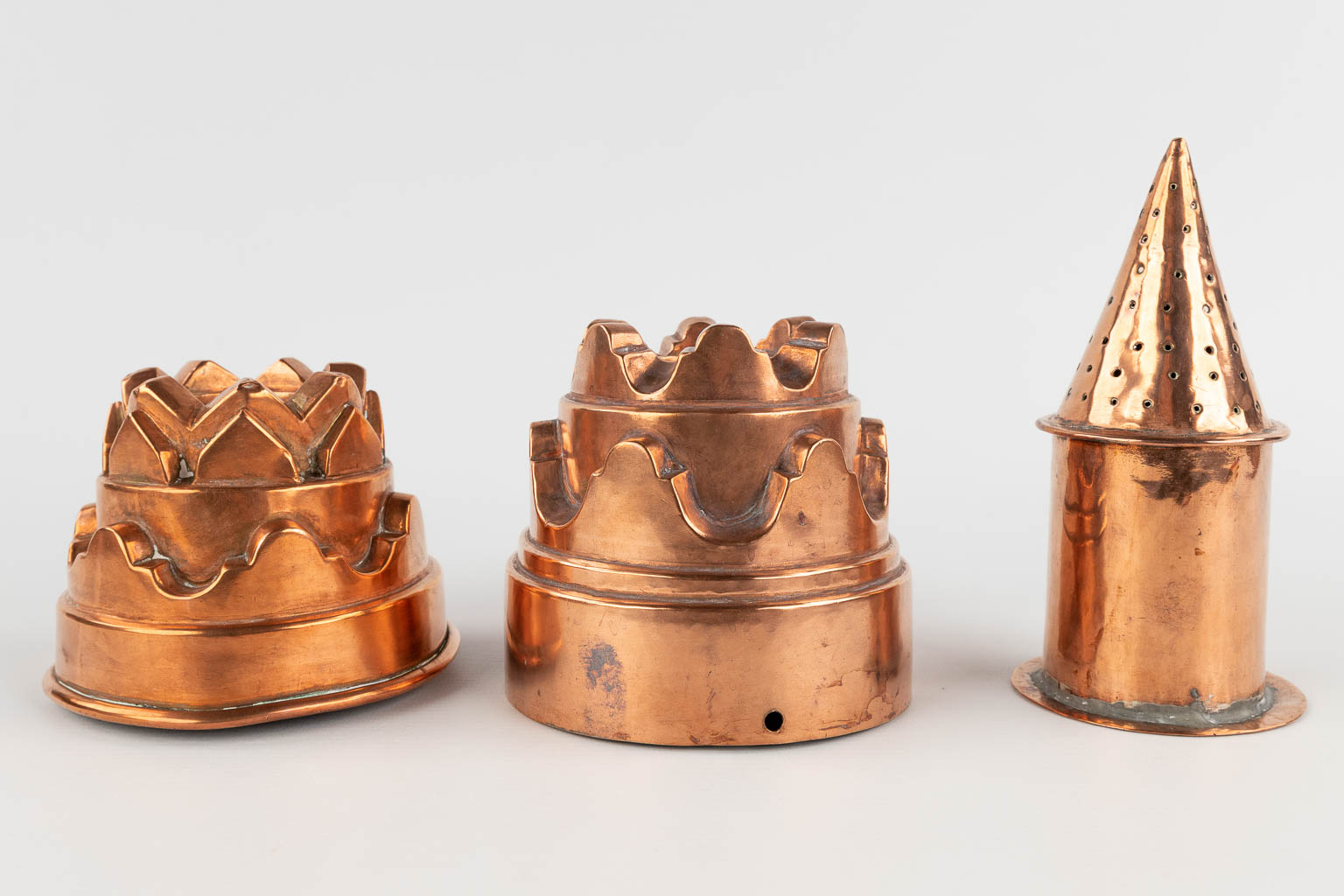 14 cake baking forms, added a sugar caster, copper. 19th/20th C. (H:9 x D:22 cm)