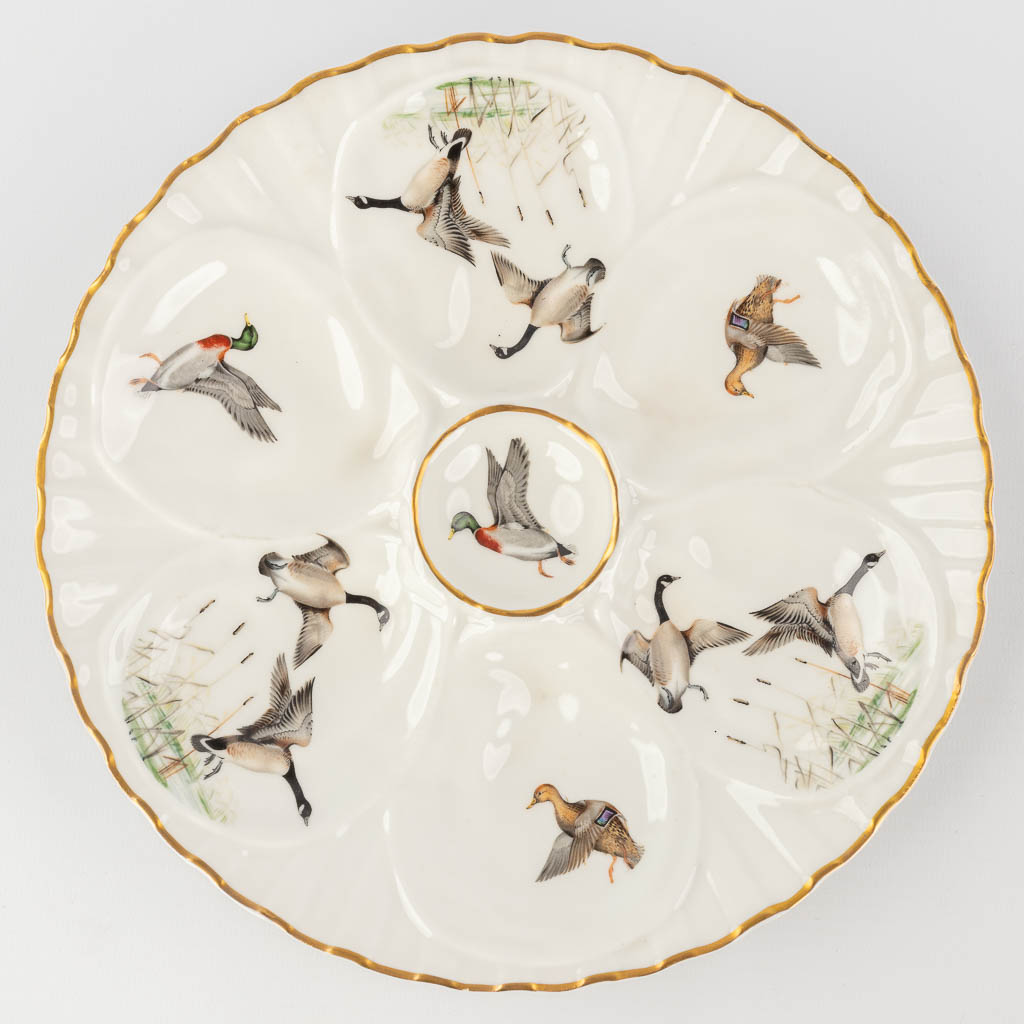 Porcelaine De Paris, France, a collection of 12 oyster plates decorated with birds. 20th C. (D: 23 cm)