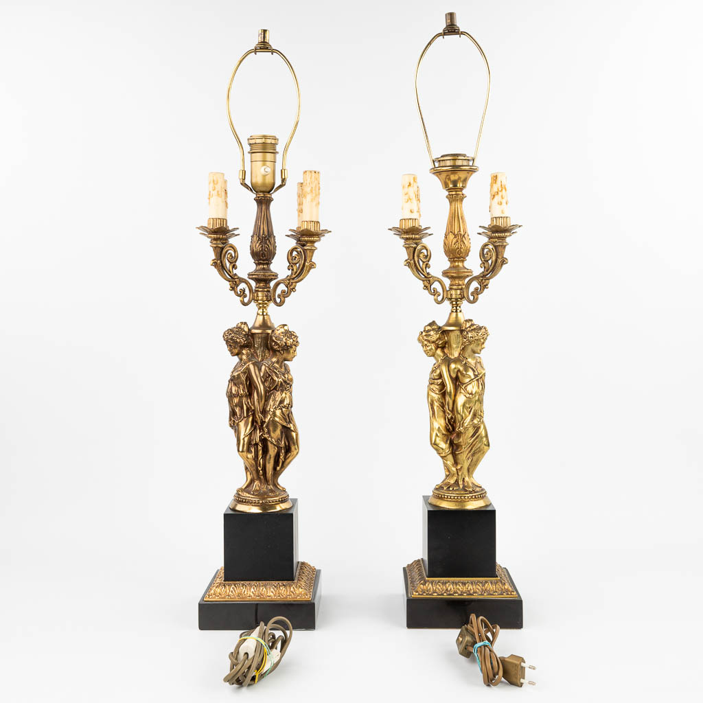 Een paar tafellampen in de vorm van de drie gratiën gemaakt uit verguld brons in Hollywood Regencystijl (H:90cm)