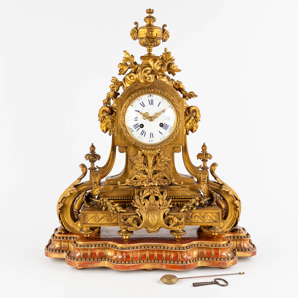 An antique mantle clock, gilt bronze in a Louis XVI style, decorated with ram's heads. Circa 1880. (W:45 x H:53 cm)