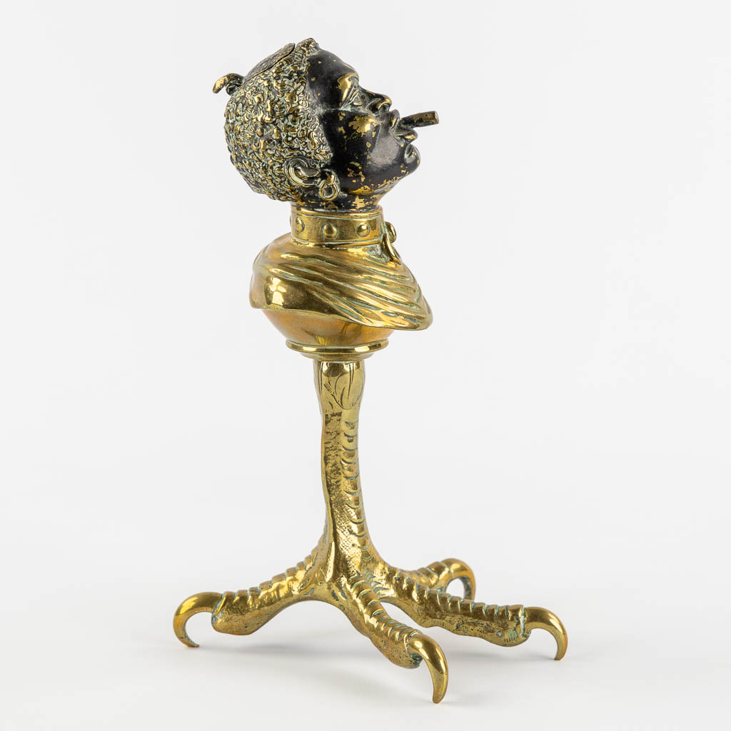 An antique Cigarette or Cigar lighter, polished bronze in the shape of a Blackamoor. 19th/20th C. (L:16 x W:13 x H:25 cm)