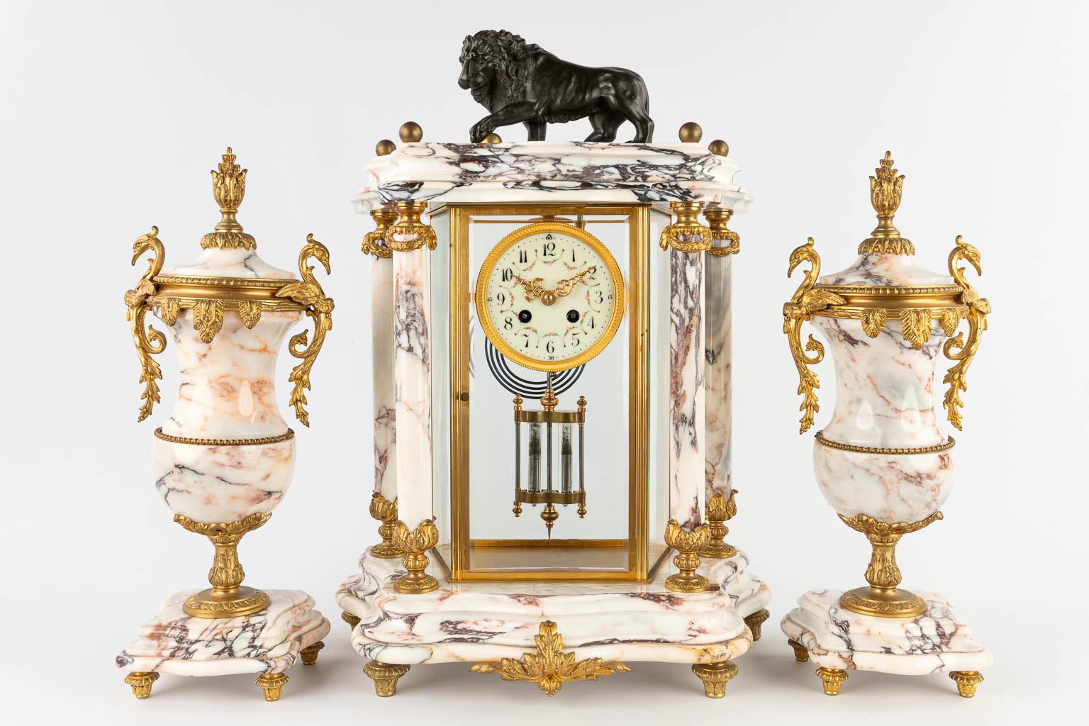 A three-piece mantle garniture portico clock and cassolettes, bronze mounted marble. 19th C. (D:19 x W:38 x H:51 cm)