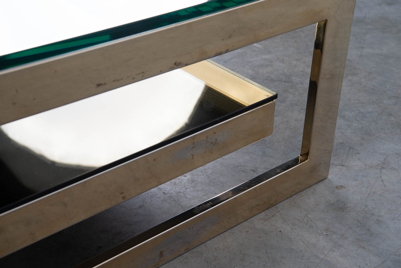 Een Belgo Chrome G-Shape salontafel gemaakt uit verguld metaal en glas. (H:38cm)