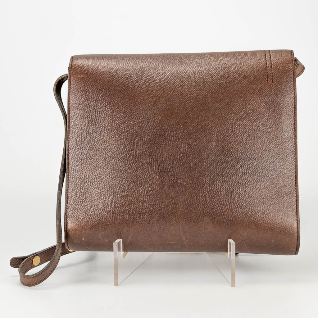 A purse made of brown leather and marked Delvaux.