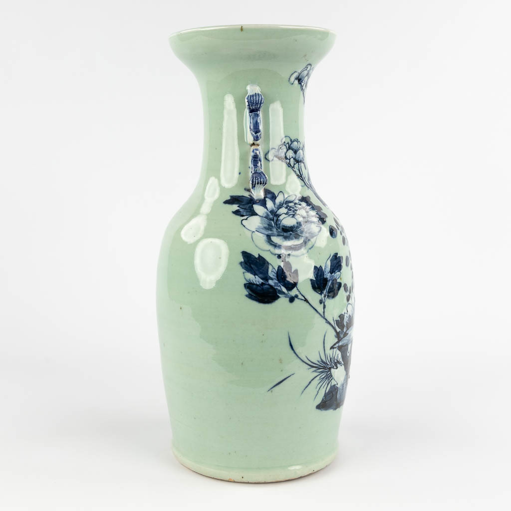 A Chinese celadon vase with blue-white decor of flora. 19th/20th C (H:42 x D:19 cm)