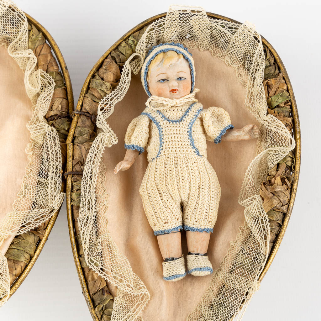 Three antique dolls, stored in a woven basket. (L:11,5 x W:17 x H:7 cm)