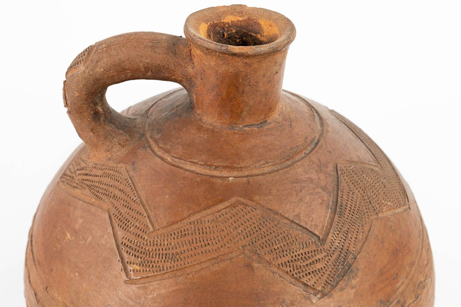 Een antieke kruik met originele stopper gemaakt uit terracotta, afgewerkt met sgraffito decor. (H:32cm)