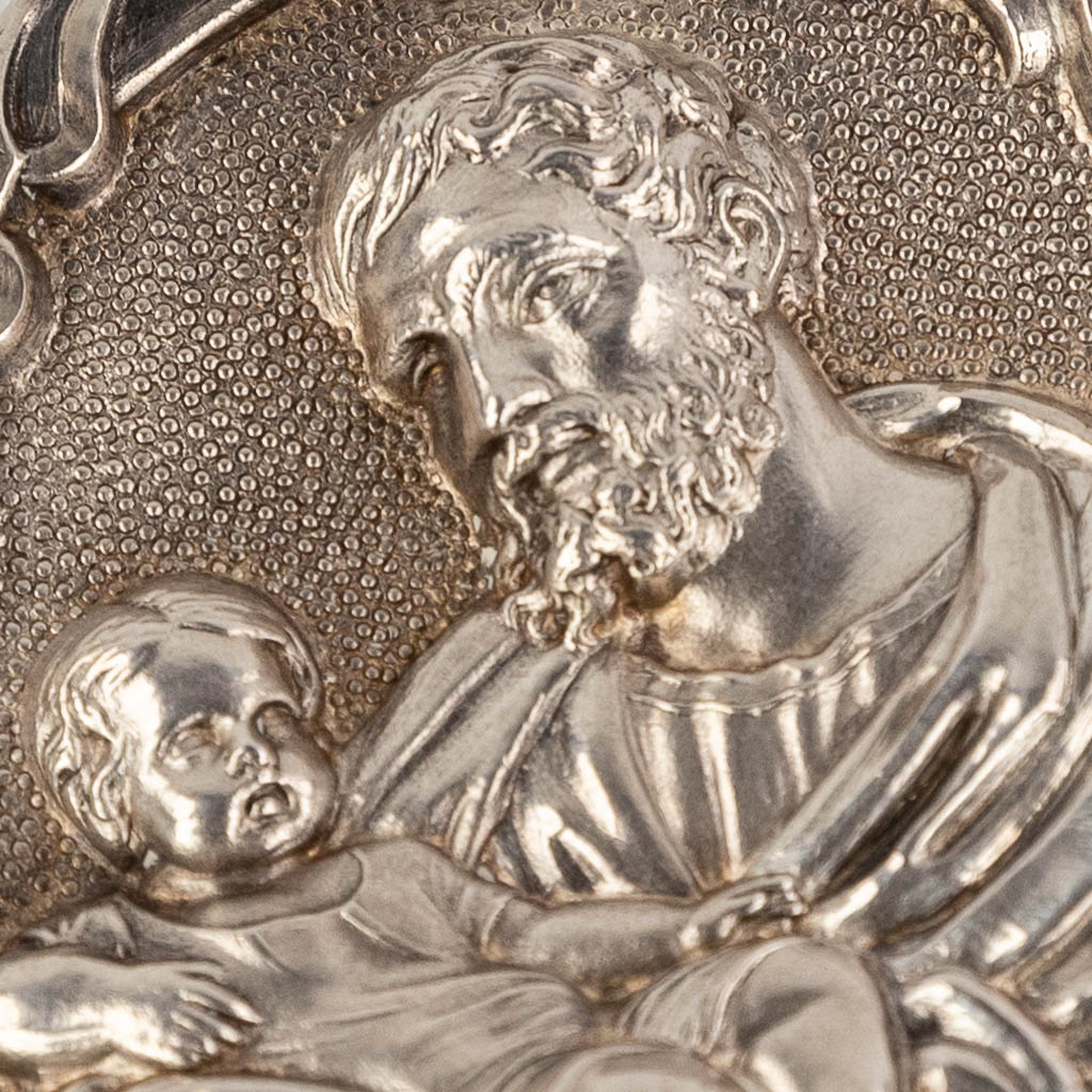 Een zilveren theca met 6 relikwieën, afgewerkt met repousse afbeelding van Heilige Jozef en Jesus. 19de eeuw. (W: 4 x H: 4,5 