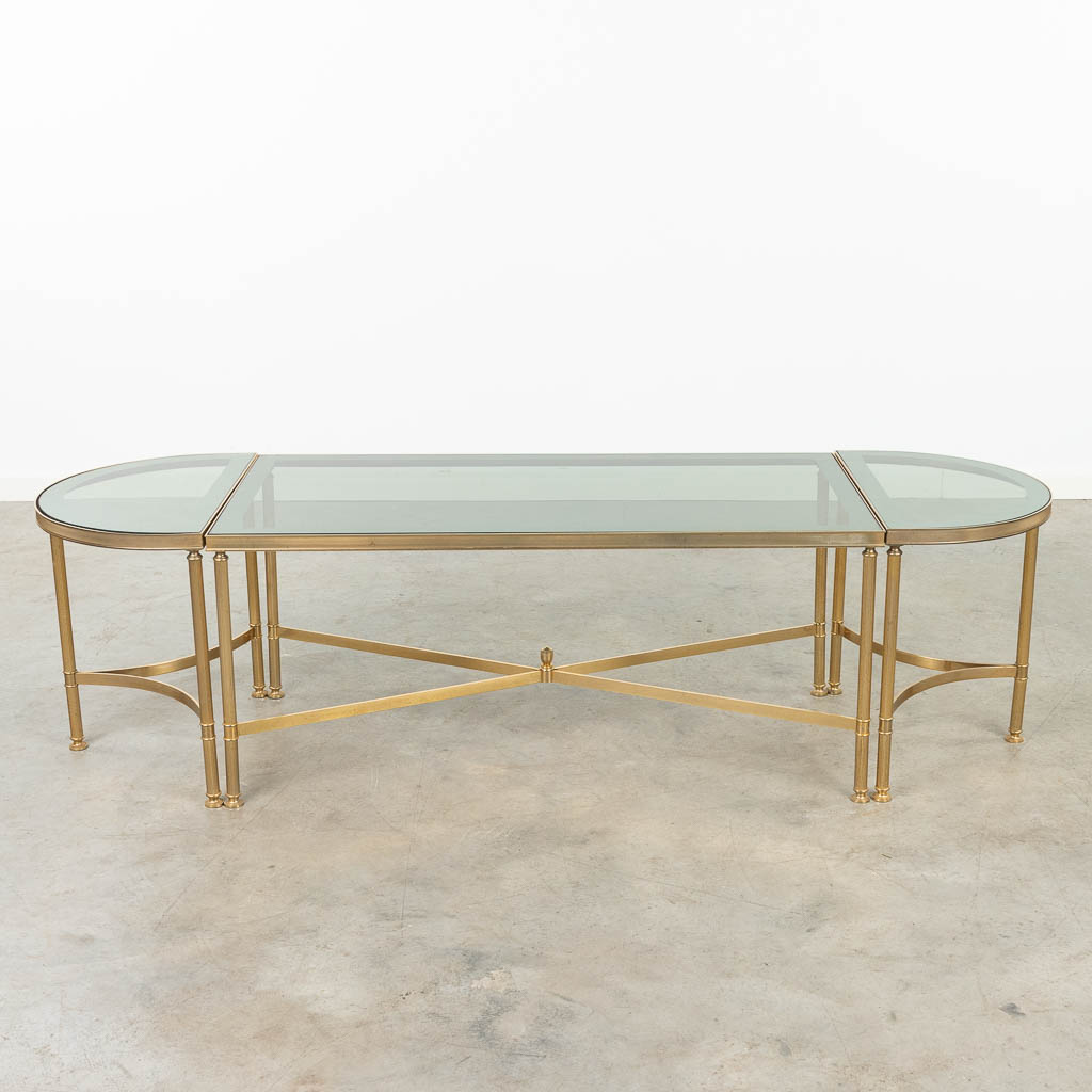  Een tripartite salontafel gemaakt uit messing en glas, in de stijl van Maison Jansen. (50 x 160 x 44cm)