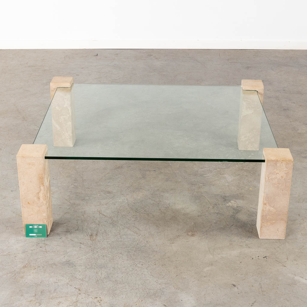 A coffee table with travertine legs, glass top. Circa 1980. (D:105 x W:105 x H:36 cm)