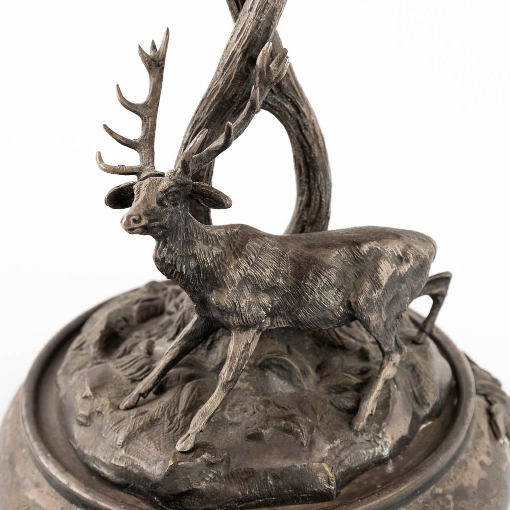 A figurine of a deer, walking under tall trees. Silver-plated bronze. Circa 1900. (D:24 x W:30 x H:33 cm)