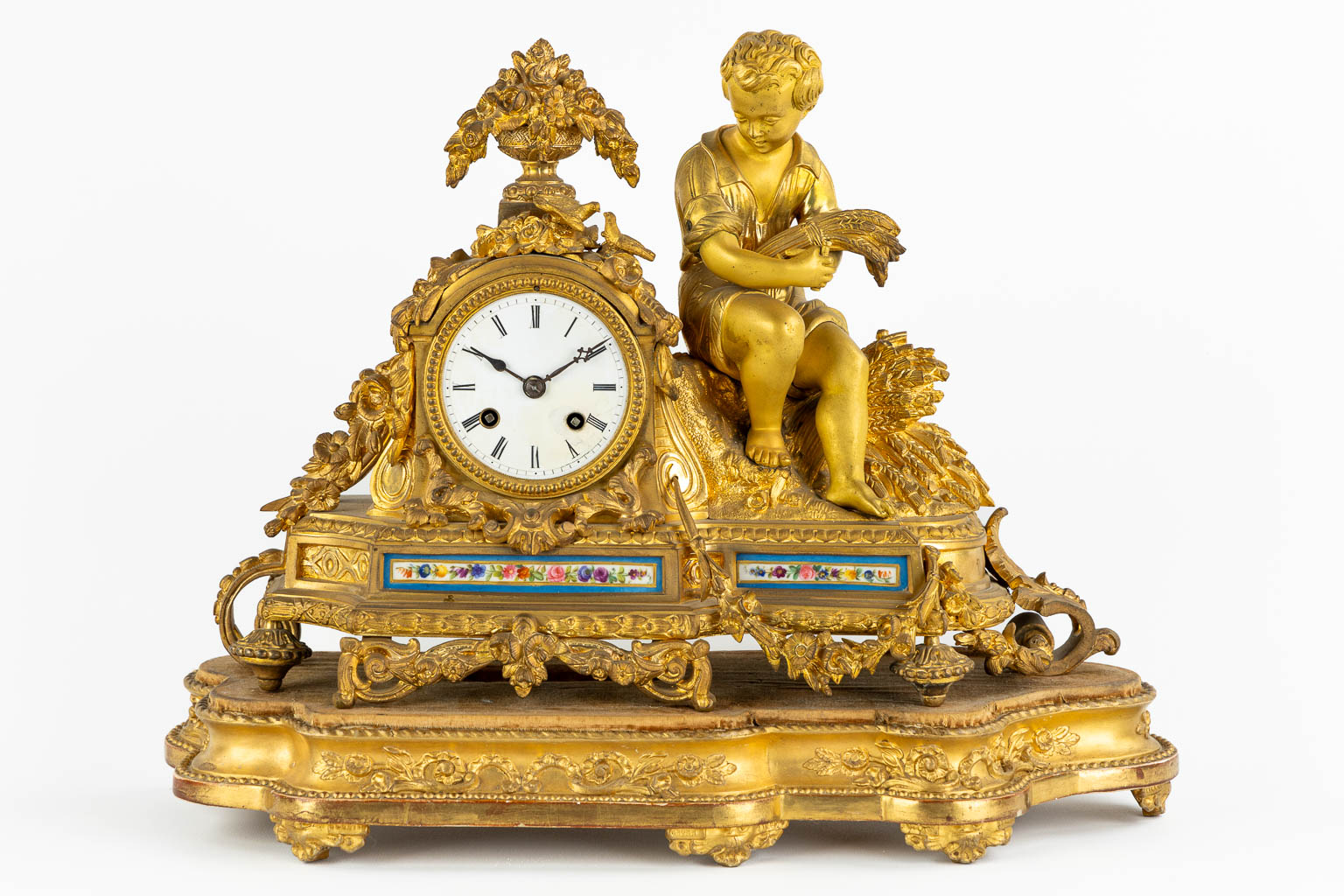 A mantle clock, gilt bronze finished with Sèvres porcelain plaques, 19th C. (L:16 x W:45 x H:35 cm)