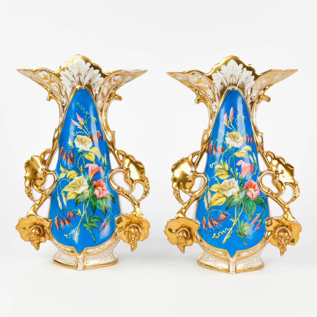 Vieux Bruxelles, A pair of vases with gold and blue decor and decorated with flowers (W:21 x H:32 cm)