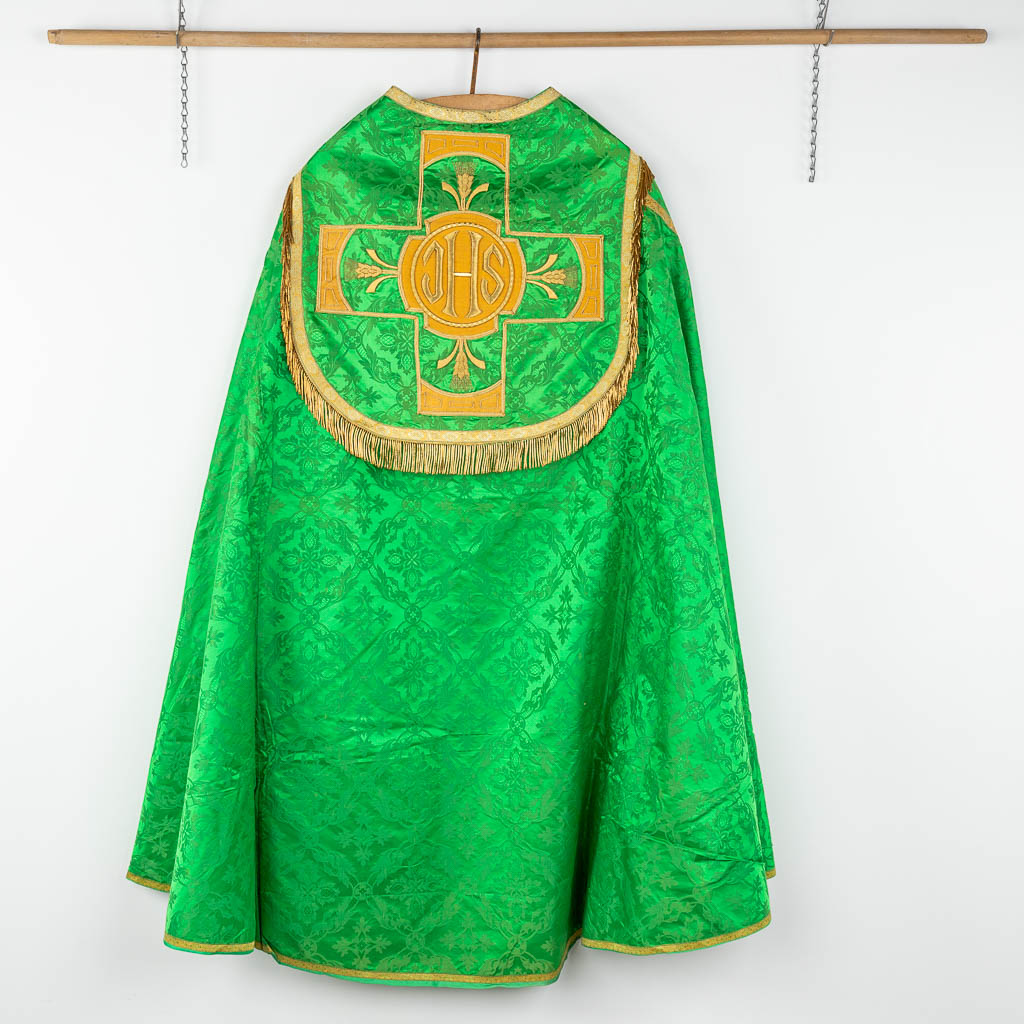 A Cope and Humeral Veil, finished with thick gold thread and green fabric and the IHS logo.