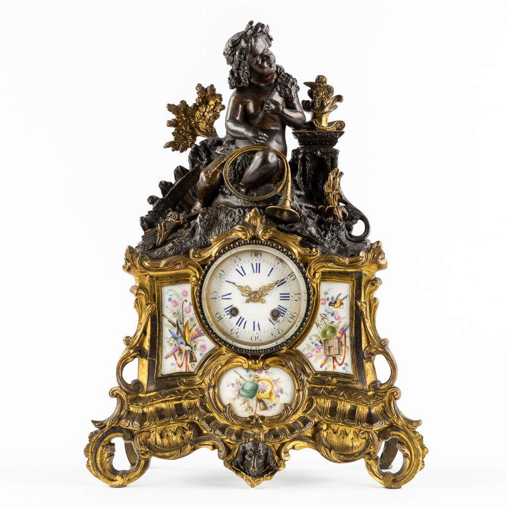 Lot 035 An mantle clock, gilt and patinated bronze in Louis XV style, porcelain plaques. 19th C. (L:13 x W:32 x H:42 cm)