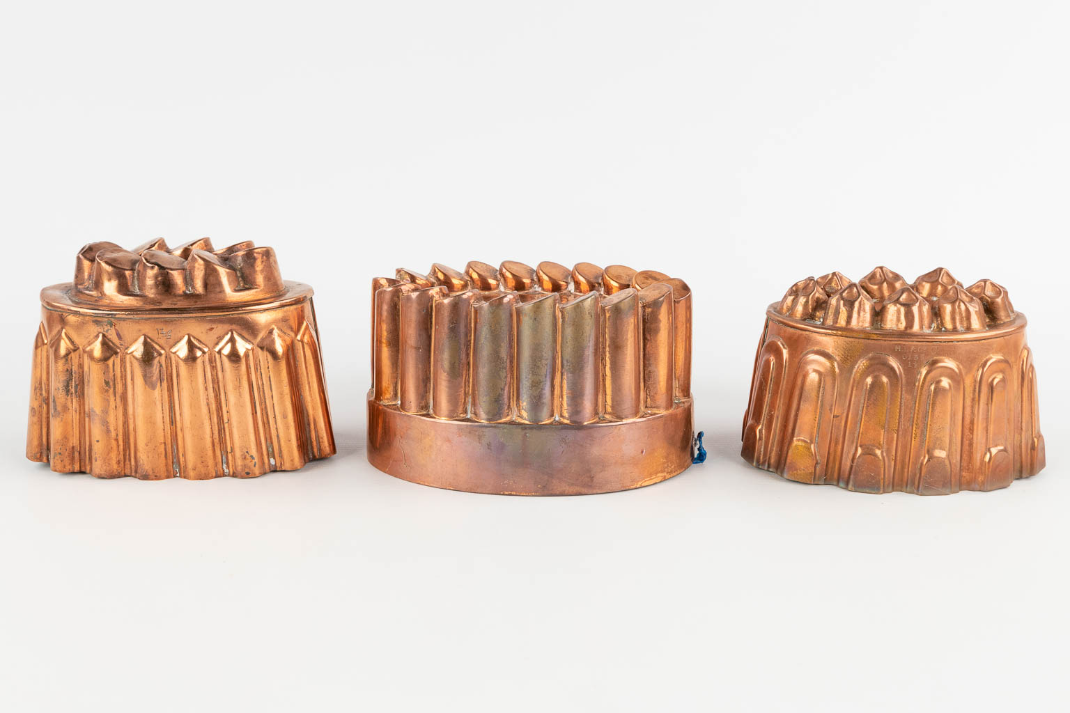14 bakvormen, bijgevoegd een suikerstrooier, koper. 19de/20ste eeuw. (H:9 x D:22 cm)
