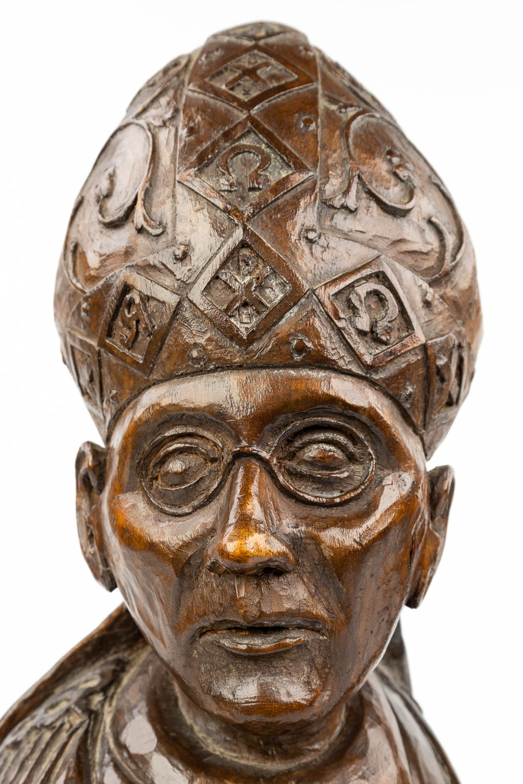 Een rijk versierde houtsculptuur van een paus of Heilige met mijter en staf 