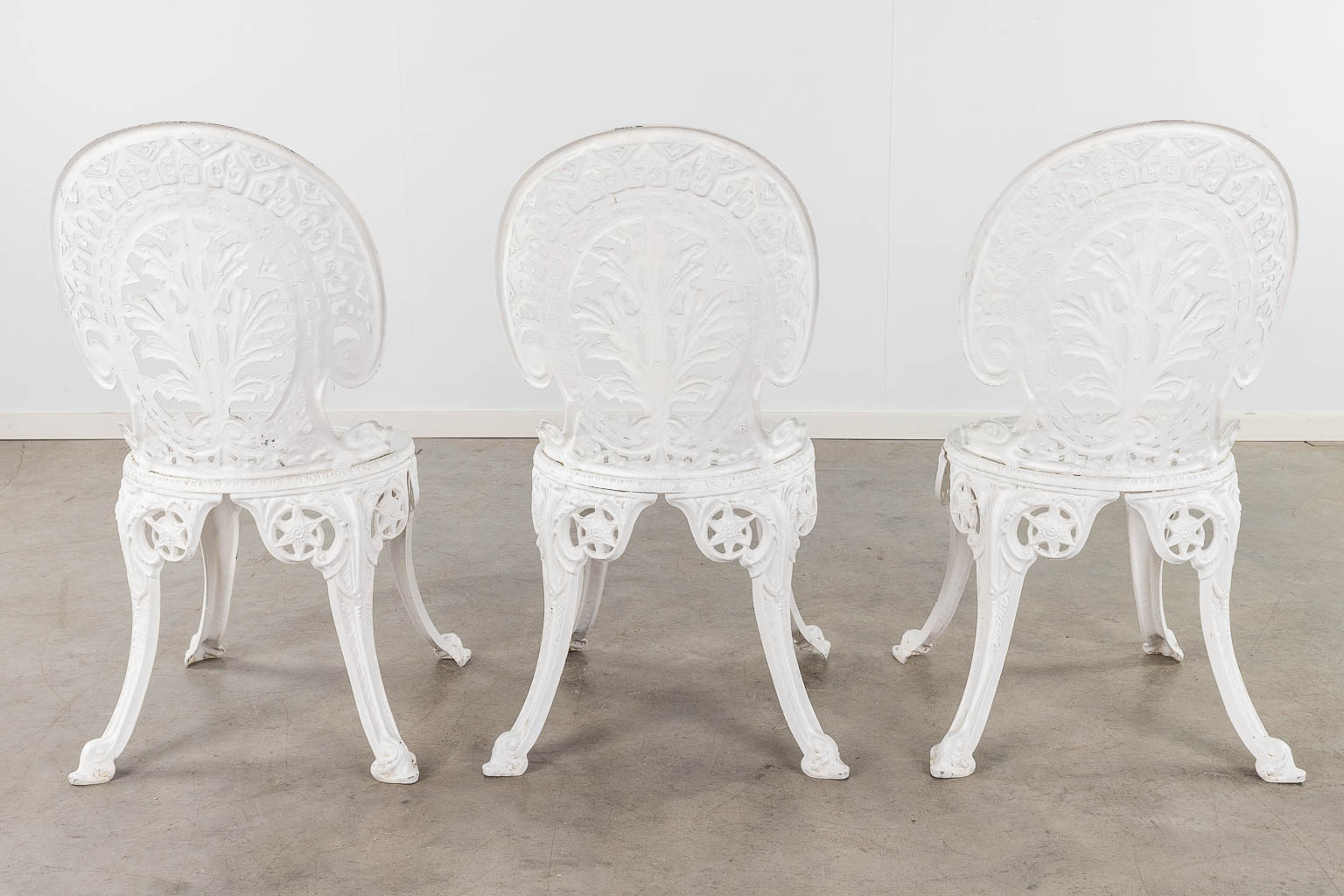 Een tuinstel bestaande uit een tafel en 3 stoelen, wit gepatineerd aluminium. (H: 65 x D: 70 cm)