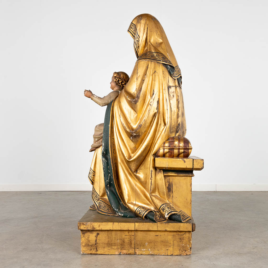 Een antieke houtsculptuur van Sint-Anna met kind, verguld en polychromie. 18de/19de eeuw. (D:51 x W:58 x H:118 cm)