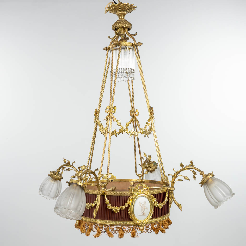 A chandelier made of bronze in Louis XVI style and finished with bisque plaques. (H:100cm)