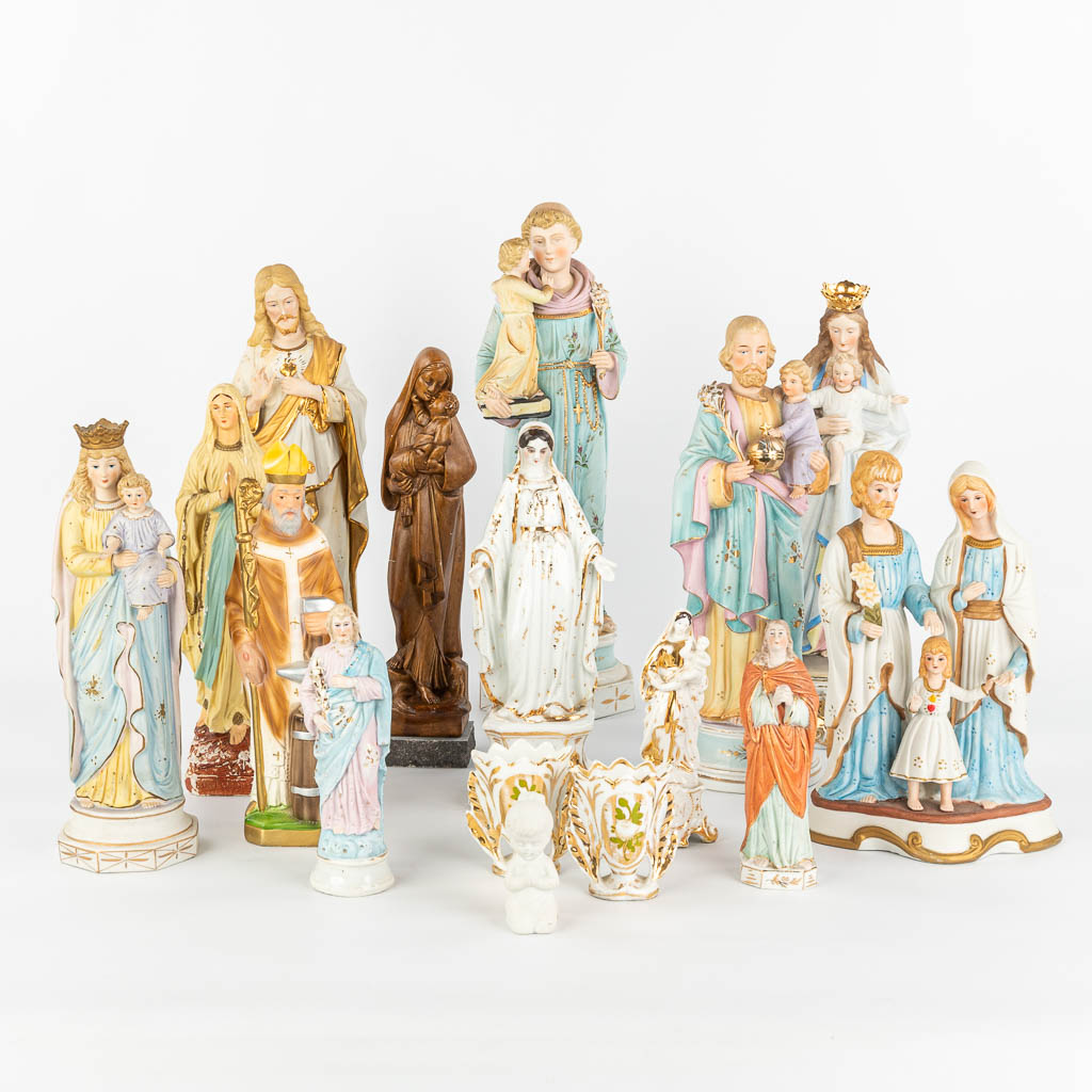 A large collection of 16 coloured bisque statues of holy figurines. (H:44cm)